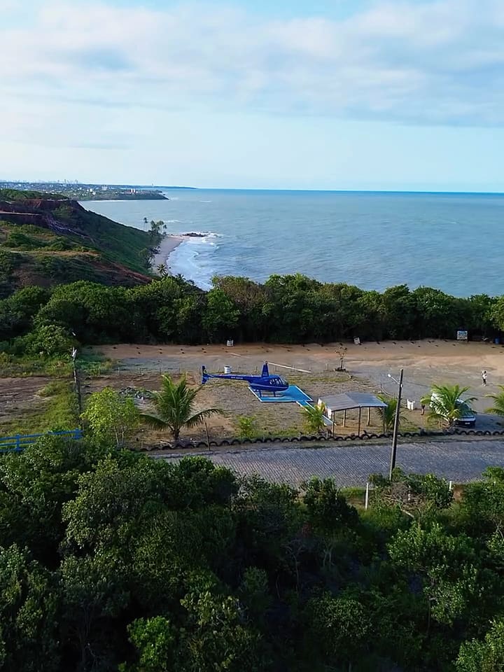 Área de pouso entre coqueiros, com o mar ao fundo, no litoral sul da Paraíba